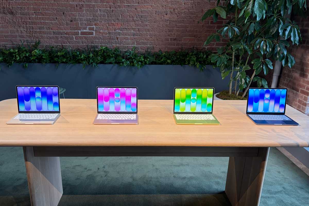 four macbook neo laptops in different colors on a table